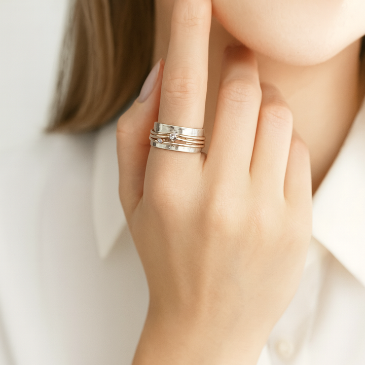 Marlène – Une bague large avec des détails en or.